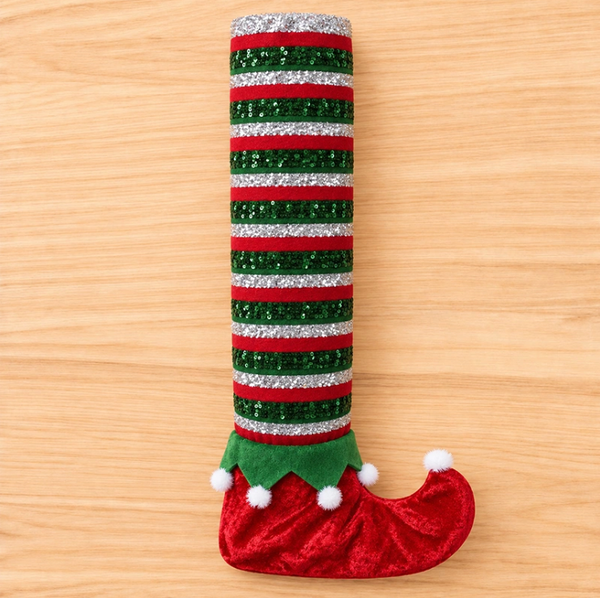 Red Elf Boot furniture leg cover with red and green stripes and white pom-poms