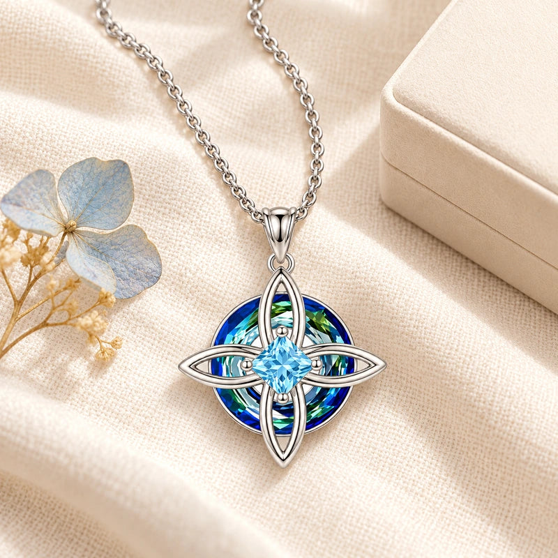 Birthstone necklace arranged on warm ivory fabric